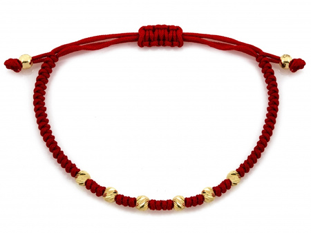 Złota bransoletka z diamentowanymi kulkami na czerwonym sznurku