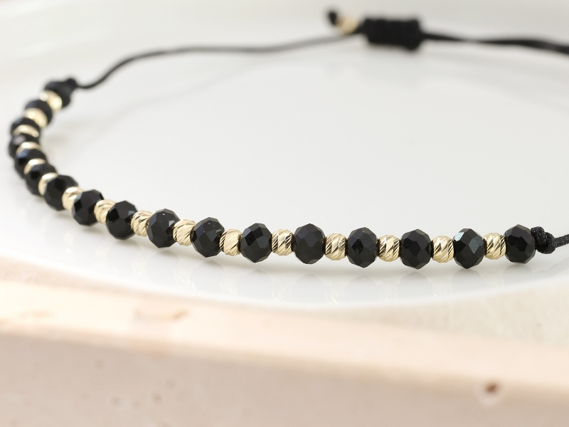 Złota bransoletka z Onyksami na czarnym sznurku