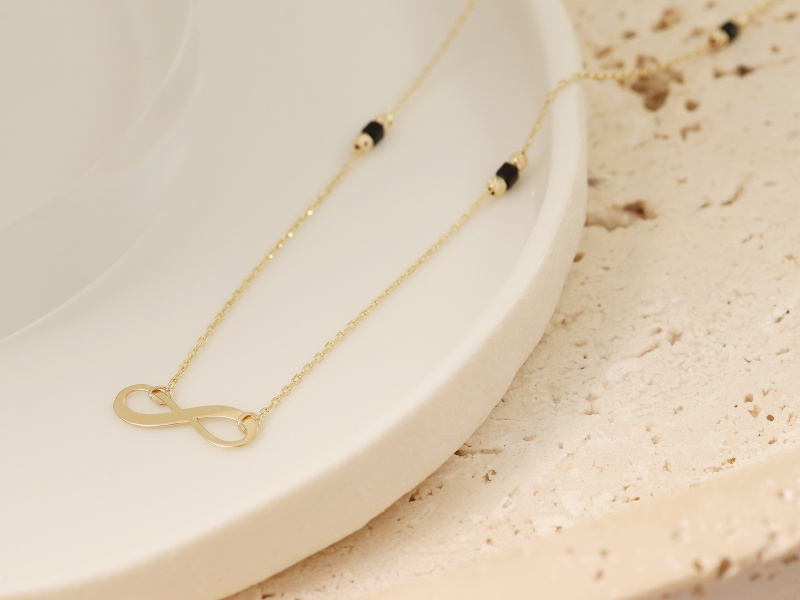 Złoty naszyjnik z nieskończonością i kamieniami
