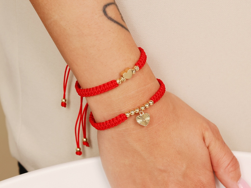 Złota bransoletka z diamentowanymi kulkami i sercem na czerwonym sznurku