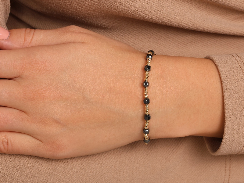 Złota bransoletka z hematytem na czarnym sznurku