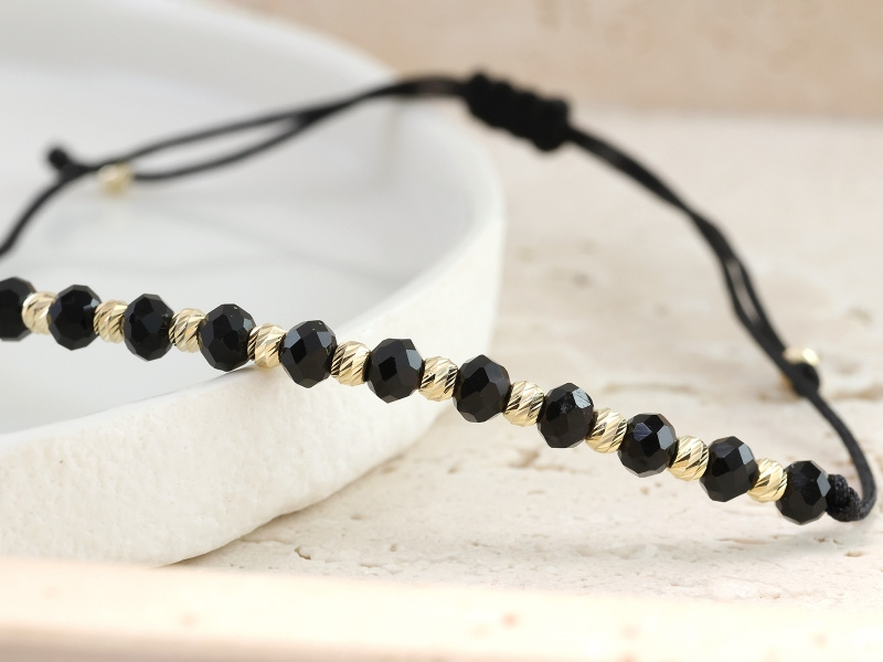 Złota bransoletka z Onyksami na czarnym sznurku