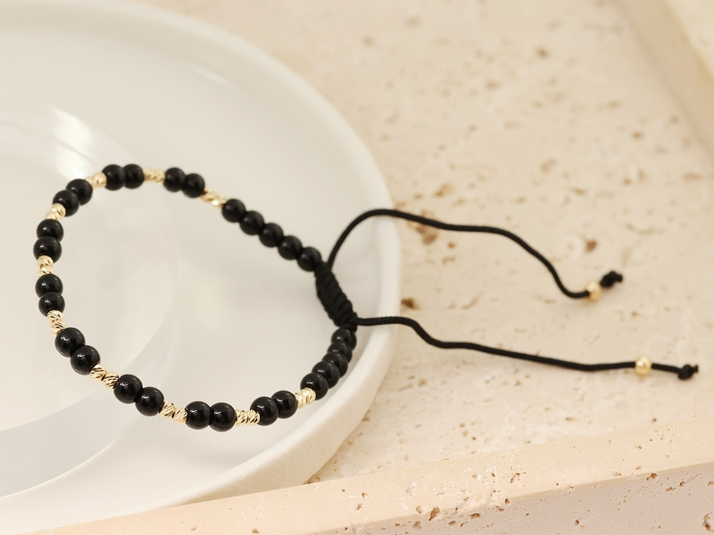 Złota bransoletka z Onyksami na czarnym sznurku